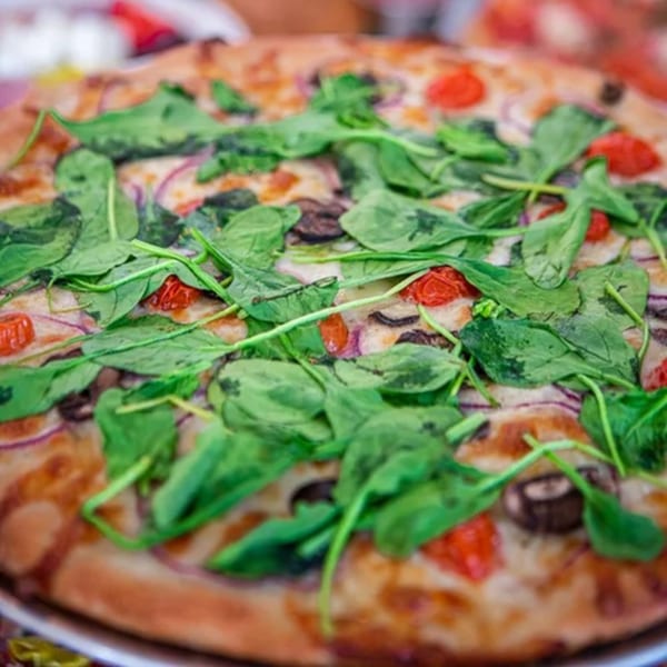 The Humble Tomato's pizza with spinach, tomatoes, mushrooms, and red onions.